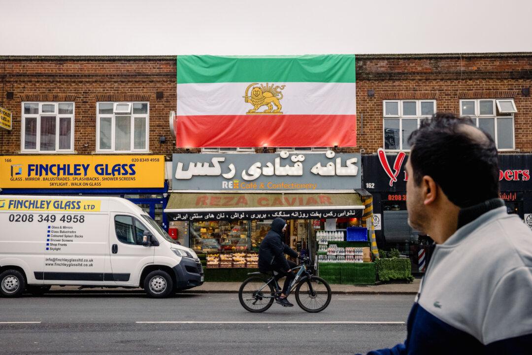 A pre-Iranian Revolution "Lion and Sun" national flag hangs from the roof of an Iranian patisserie in London on March 6, 2026. (Jack Taylor/Getty Images)