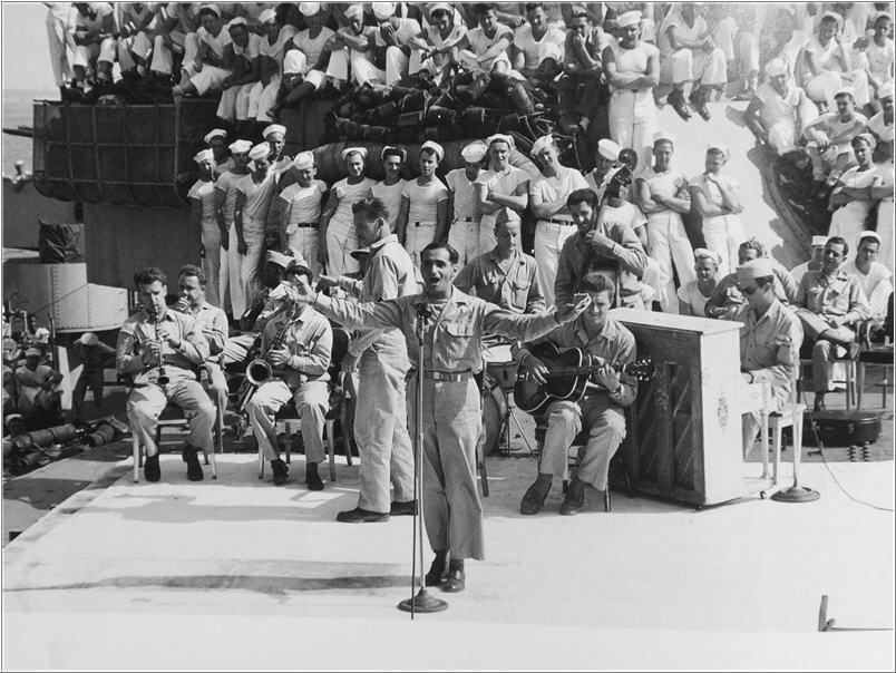 Irving Berlin singing and conducting aboard USS Arkansas, 1944. (Public Domain)