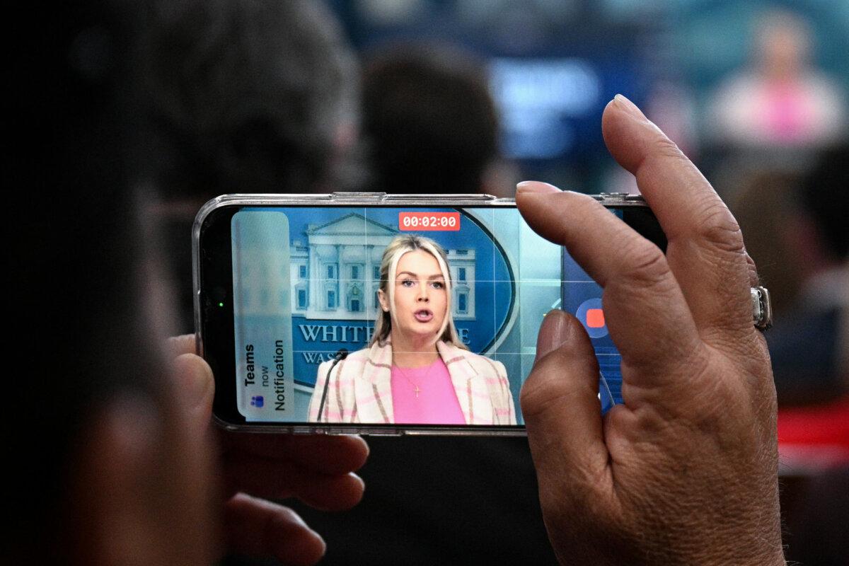 A journalist uses a phone to take a video as White House press secretary Karoline Leavitt speaks during a press briefing in the Brady Briefing Room of the White House in Washington on March 10, 2026. (Jim Watson/AFP via Getty Images)