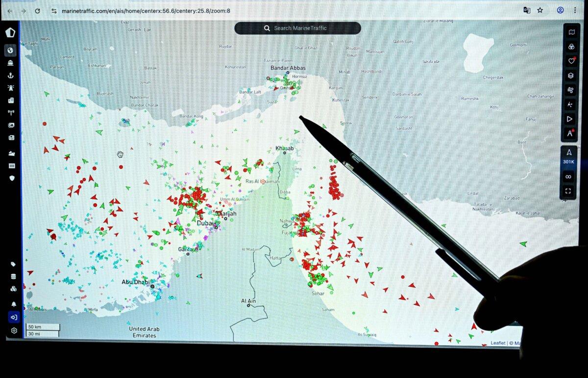 A person points to a page on the Marinetraffic website showing commercial boat traffic on the edge of the Strait of Hormuz near the Iranian coast, on March 4, 2026. (Julien de Rosa/AFP via Getty Images)