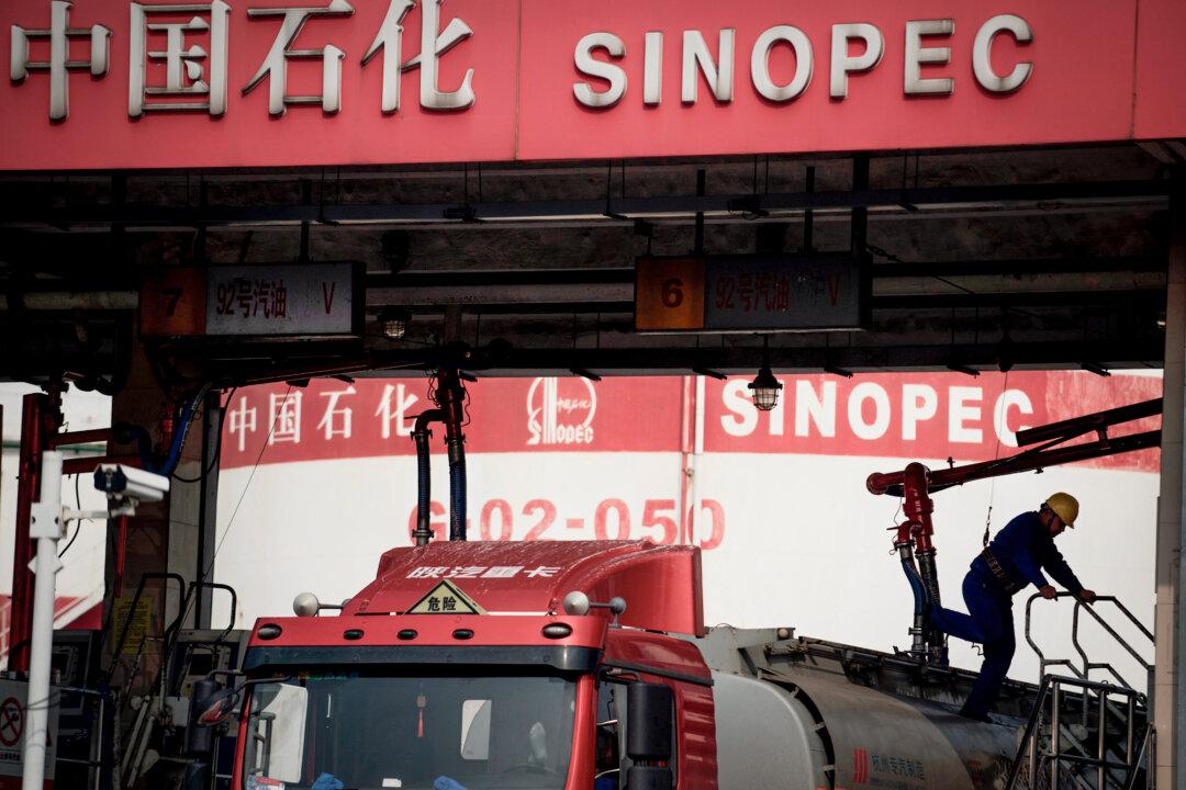 A man works in a Sinopec, China Petroleum and Chemical Corporation, filling station in Shanghai on March 22, 2018. (Johannes Eisele/AFP via Getty Images)