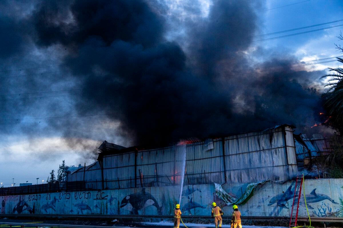 Firefighters try to extinguish a fire at a warehouse that occurred amid a barrage of Iranian missiles in Holon, Israel, on March 13, 2026. (Erik Marmor/Getty Images)