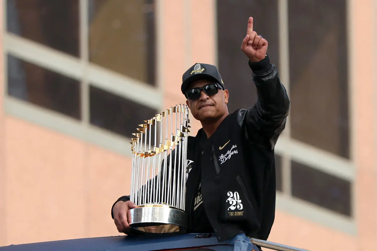 Manager Dave Roberts of the Los Angeles Dodgers reacts with the trophy atop a bus during the Los Angeles Dodgers World Series Parade in Los Angeles on November 03, 2025. (Luke Hales/Getty Images)