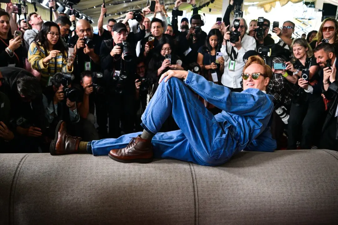 Host Conan O'Brien lies on the carpet as he participates in the 98th Oscars arrivals carpet roll out at the Dolby Theatre at Ovation in Hollywood, Calif., on March 11, 2026, ahead of the Academy Awards. (Frederic J. Brown / AFP via Getty Images)