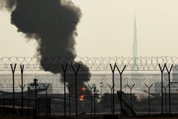 The Dubai skyline with the landmark Burj Khalifa skyscraper (R), as a smoke plume rises from an ongoing fire near Dubai International Airport on March 16, 2026. (AFP via Getty Images)