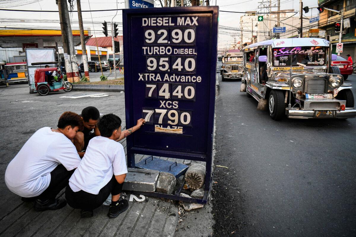 Workers change the price label of fuel at a petrol station in Manila, Philippines, on March 17, 2026. Oil climbed again in Asia on March 17 after prices retreated a day earlier, with investors remaining focused on the Strait of Hormuz. (Ted Aljibe/AFP via Getty Images)