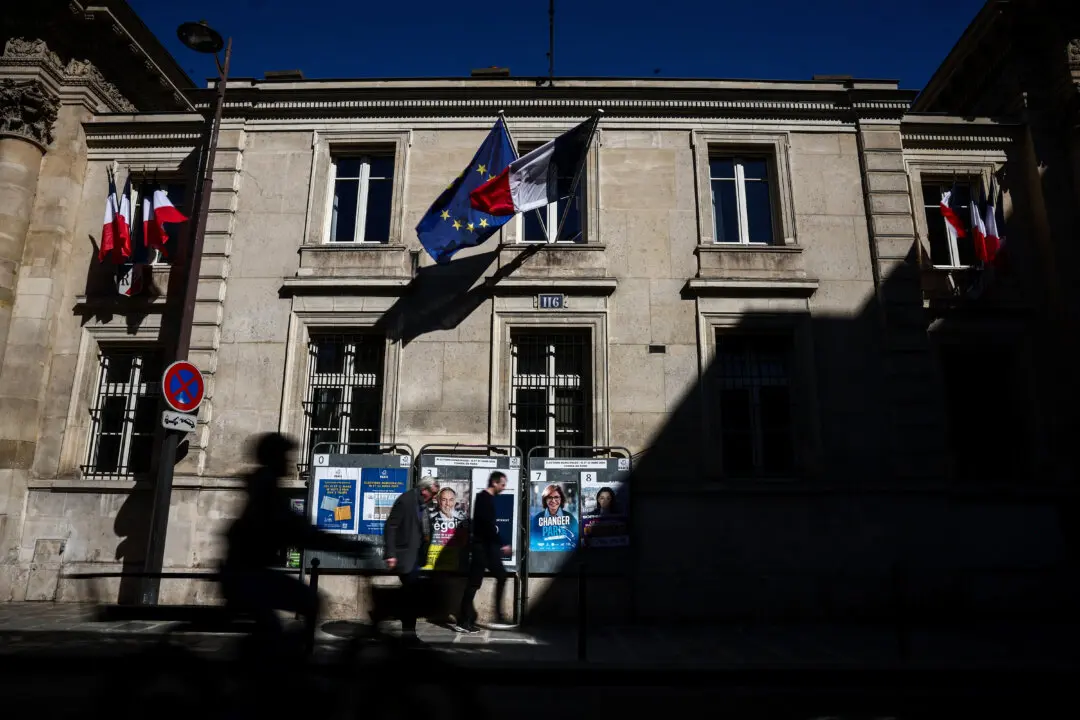People pass by campaign posters of the three remaining candidates for Paris mayor (From L) socialist Emmanuel Gregoire, right-leaning Rachida Dati and left-leaning Sophia Chikirou, outside Paris' 7th arrondissement city hall, four days ahead of France's municipal elections second round, in Paris on March 18, 2026. (Guillaume BAPTISTE / AFP via Getty Images)