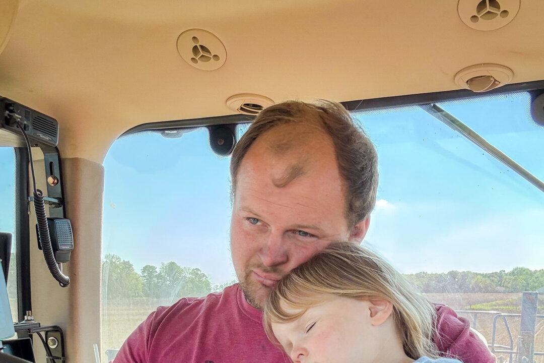 Tyler Everett drives a tractor with his daughter, Charlee, at Everett Farms in Lebanon, Ind., on May 18, 2025. Everett said he hopes his children will one day take over the farm if that’s the path they choose. (Courtesy of Tyler Everett)
