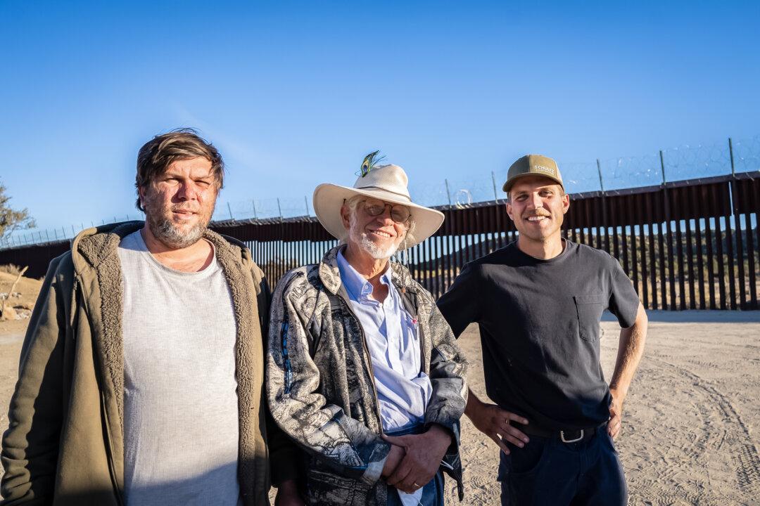 Sam Schultz (C) works with volunteers feeding migrants hot meals in Jacumba, Calif., on Oct. 31, 2023. (John Fredricks/The Epoch Times)