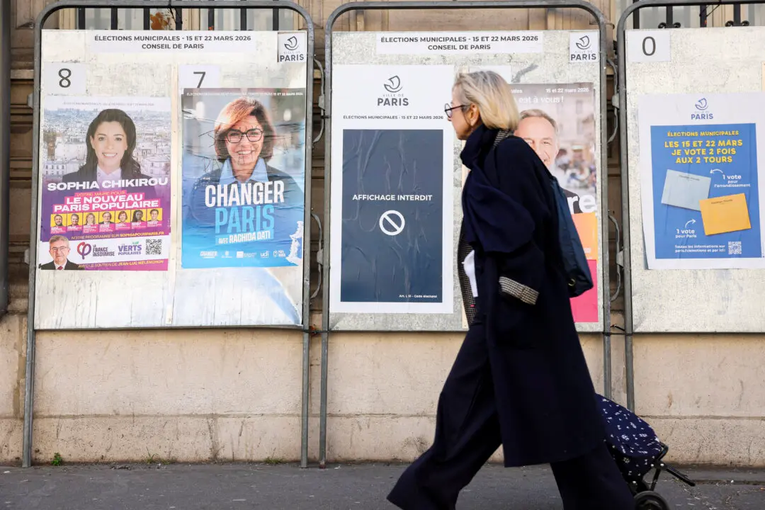 A pedestrian walks past campaign posters of mayoral canidates Sophia Chikirou (L) and Rachida Dati, displayed in central Paris on March 19, 2026, ahead of the second round of France's municipal elections. (Photo by Charlotte SIEMON / AFP via Getty Images)