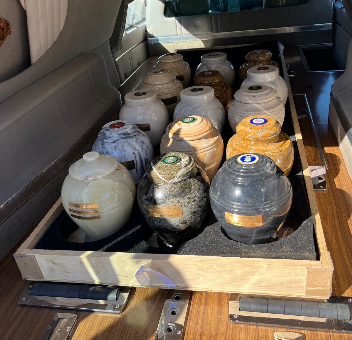 The cremation remains of veterans sit in donated urns in the back of a hearse before interment in the National Memorial Cemetery of Arizona on March 18, 2026. (Allan Stein/The Epoch Times)