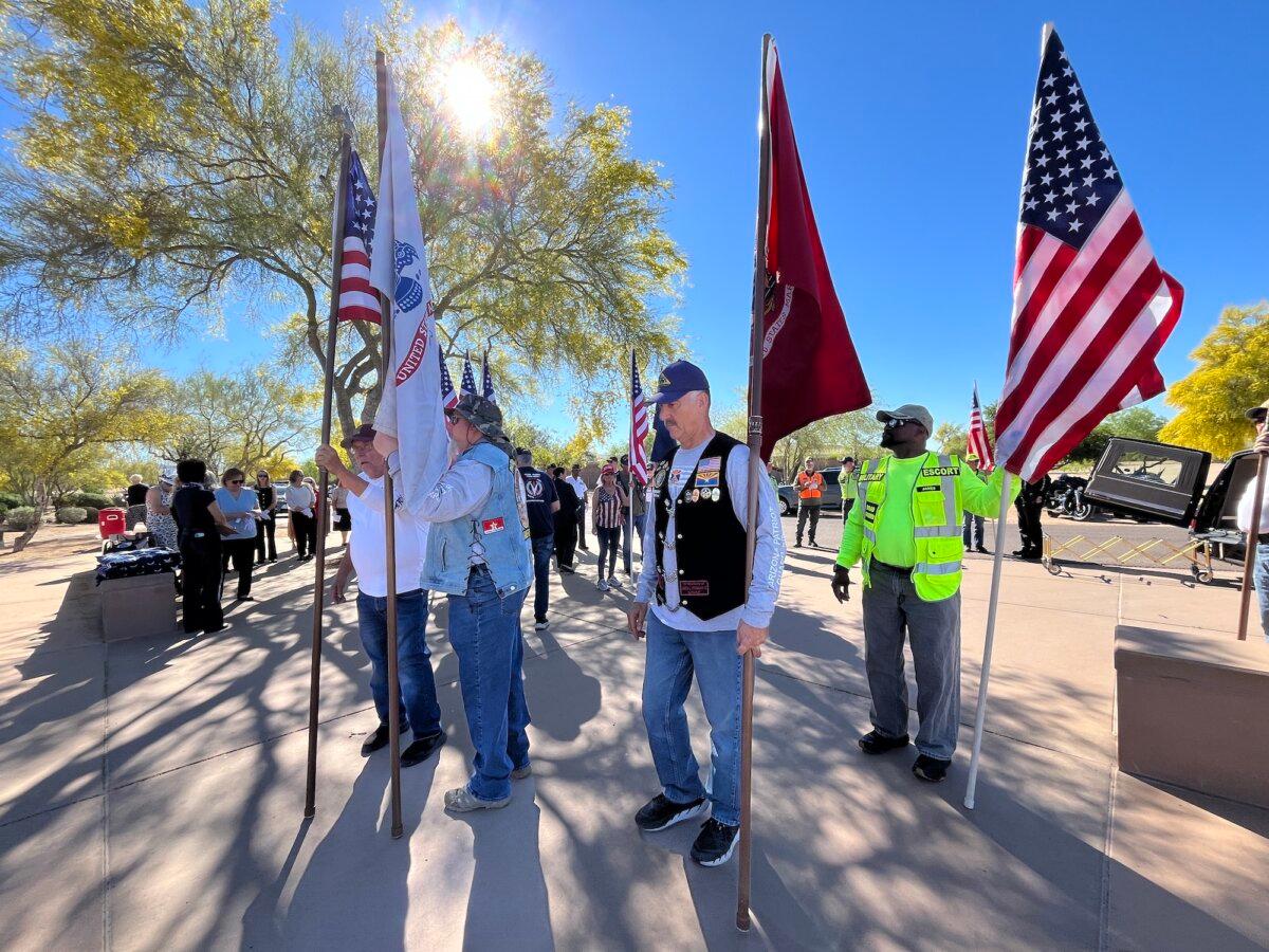 Volunteers gather during a funeral service for 14 veterans and a spouse at the National Memorial Cemetery of Arizona in Phoenix on March 18, 2026. (Allan Stein/The Epoch Times)