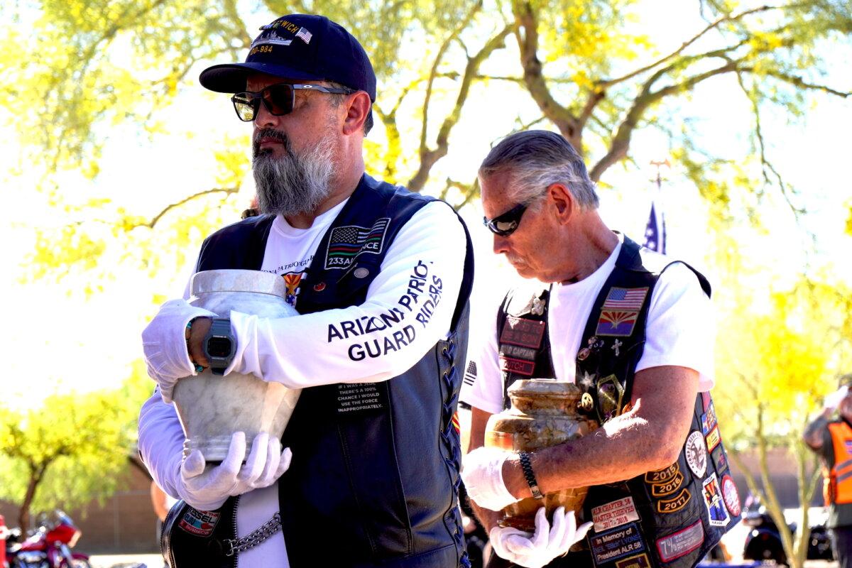 Volunteers carry urns containing the cremated remains of two veterans during a service at the National Memorial Cemetery of Arizona in Phoenix on March 18, 2026. (Allan Stein/The Epoch Times)