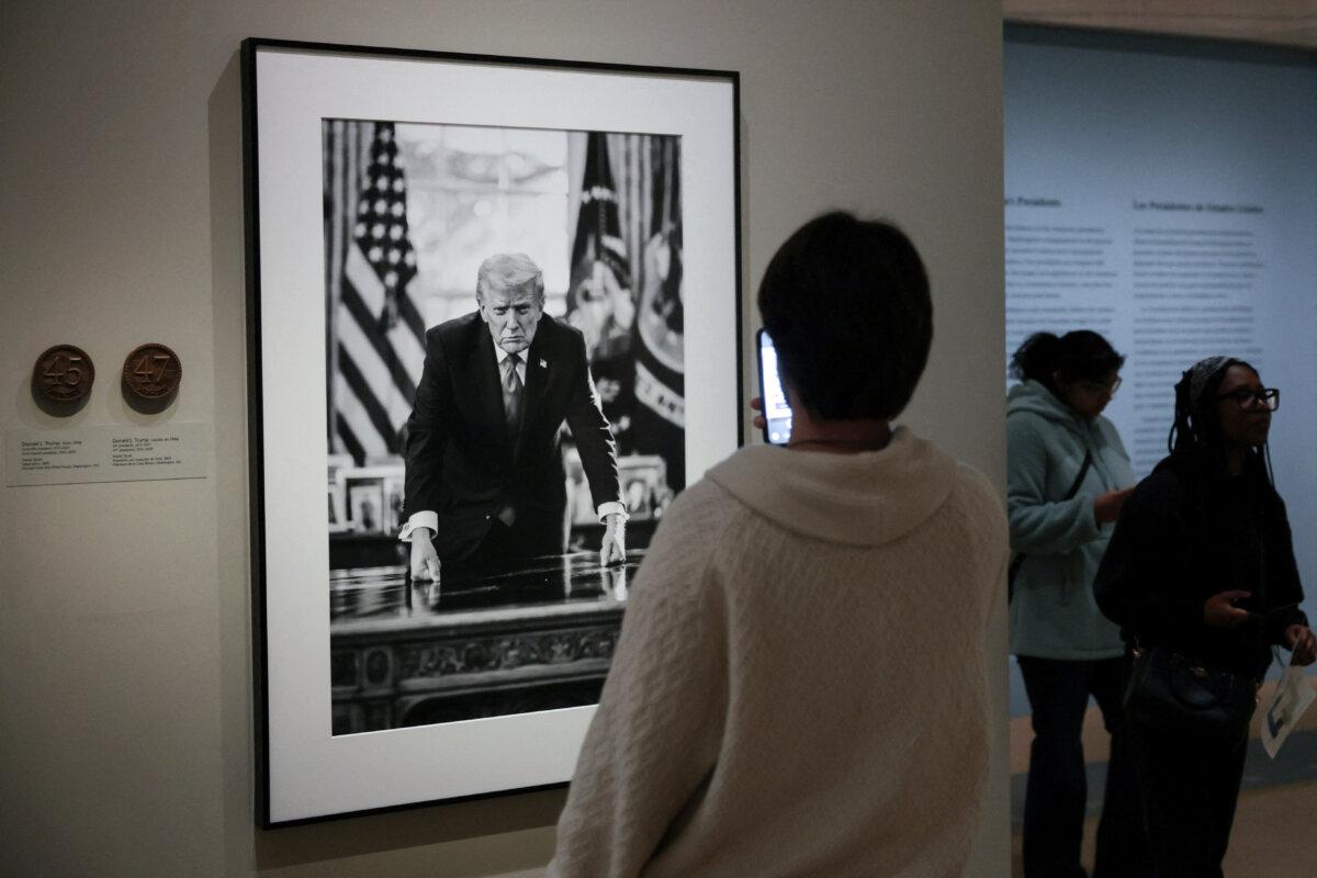 People view the portrait of President Donald Trump, taken by official White House photographer Daniel Torok, which is the basis for U.S. Mint semiquincentennial commemorative coin design, on display at the Smithsonian National Portrait Gallery in Washington on March 19, 2026. (Jonathan Ernst/Reuters)
