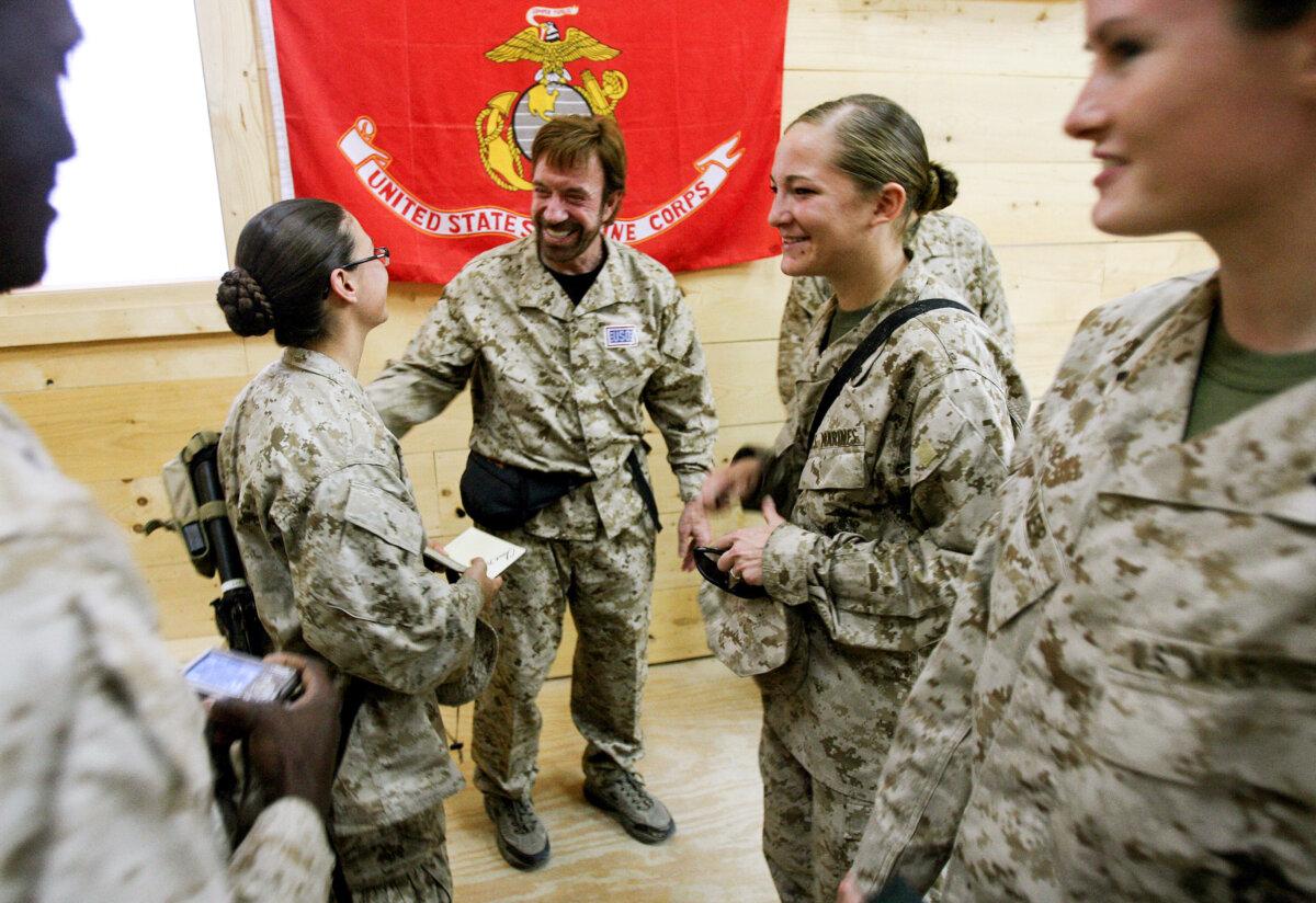 U.S. Marines and sailors from the California-based Regimental Combat Team 7 meet action-movie star Chuck Norris, at Al Asad air base in Al Anbar Province, West of Baghdad, on Oct. 31, 2006. (IM GOODWIN/USMC/AFP via Getty Images)