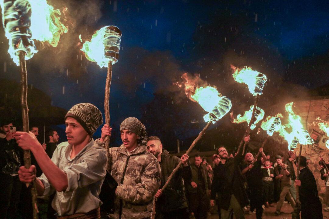 TOPSHOT - Iraqi Kurds march with torches during a procession to celebrate the Nowruz New Year festival in the town of Akre, about 100 kms north of Arbil, in Iraq's northern autonomous Kurdish region on March 20, 2026. Millions of people across the Middle East, Asia and Eastern Europe celebrate Nowruz new year festival, which marks the start of spring. (Photo by Safin HAMID / AFP via Getty Images)