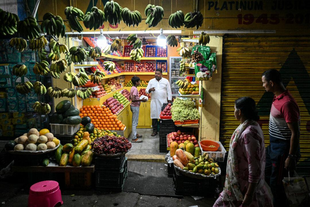 A vendor speaks to the customer at a fruit shop in Aberdeen Bazaar, Sri Vijaya Puram, the capital city of the Andaman and Nicobar Islands on March 20, 2026. (Photo by R. Satish BABU / AFP via Getty Images)