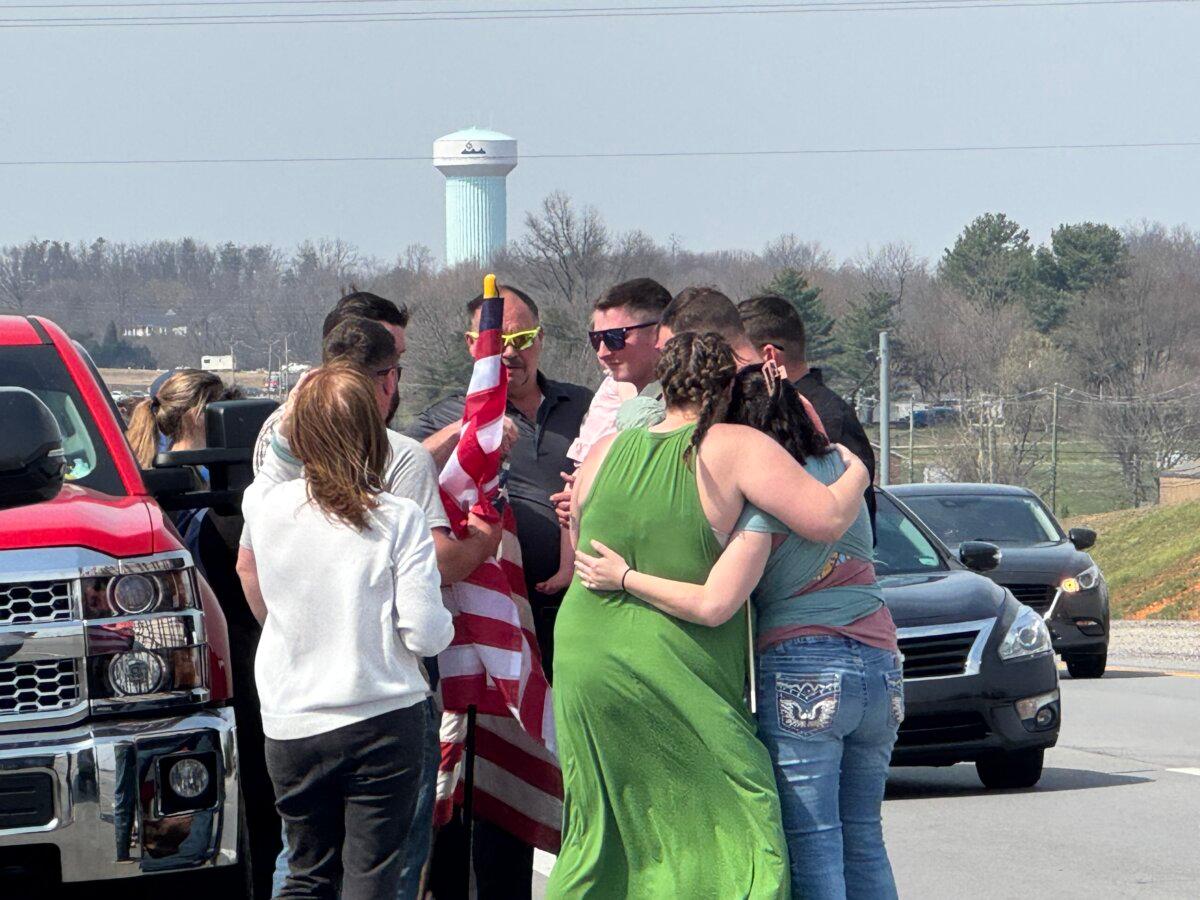 Friends of a fallen soldier, Army Staff Sgt. Benjamin Pennington, comfort each other after a procession honoring him passed through Hardin County, Ky., on March 20, 2026. (Courtesy of Daniel O'Dell)