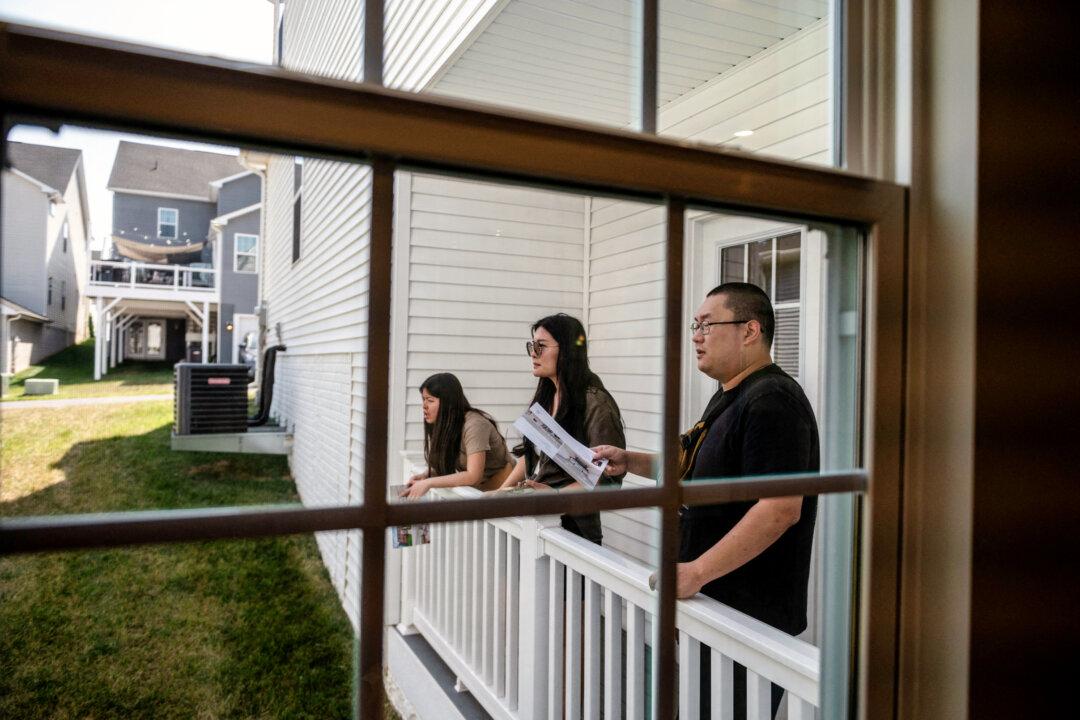 Prospective homebuyers look from a balcony during an open house in Clarksburg, Md., on Sept. 3, 2023. As homeownership grows more out of reach for younger Americans, co-ownership—where friends, family, or partners jointly purchase a home—is becoming more common. (Roberto Schmidt/AFP via Getty Images)