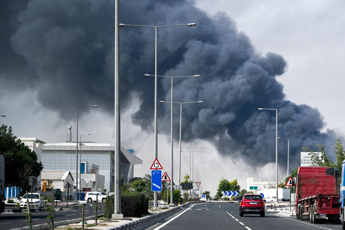 Motorists drive past a plume of smoke rising from a reported Iranian strike in the industrial district of Doha, Qatar, on March 1, 2026. (Mahmud Hams/AFP via Getty Images)