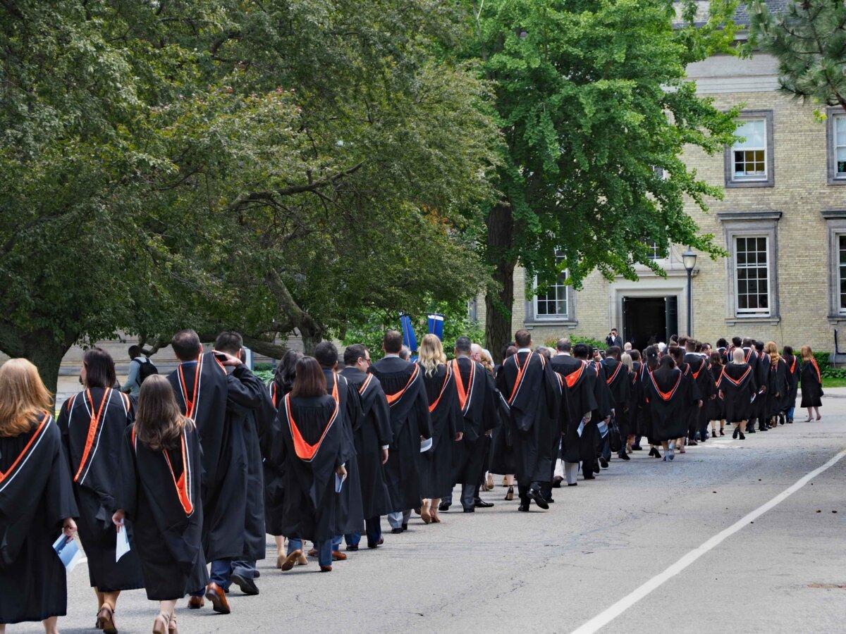 A procession of university students walking toward their graduation ceremony at the University of Toronto. (Spiroview Inc/Shutterstock)