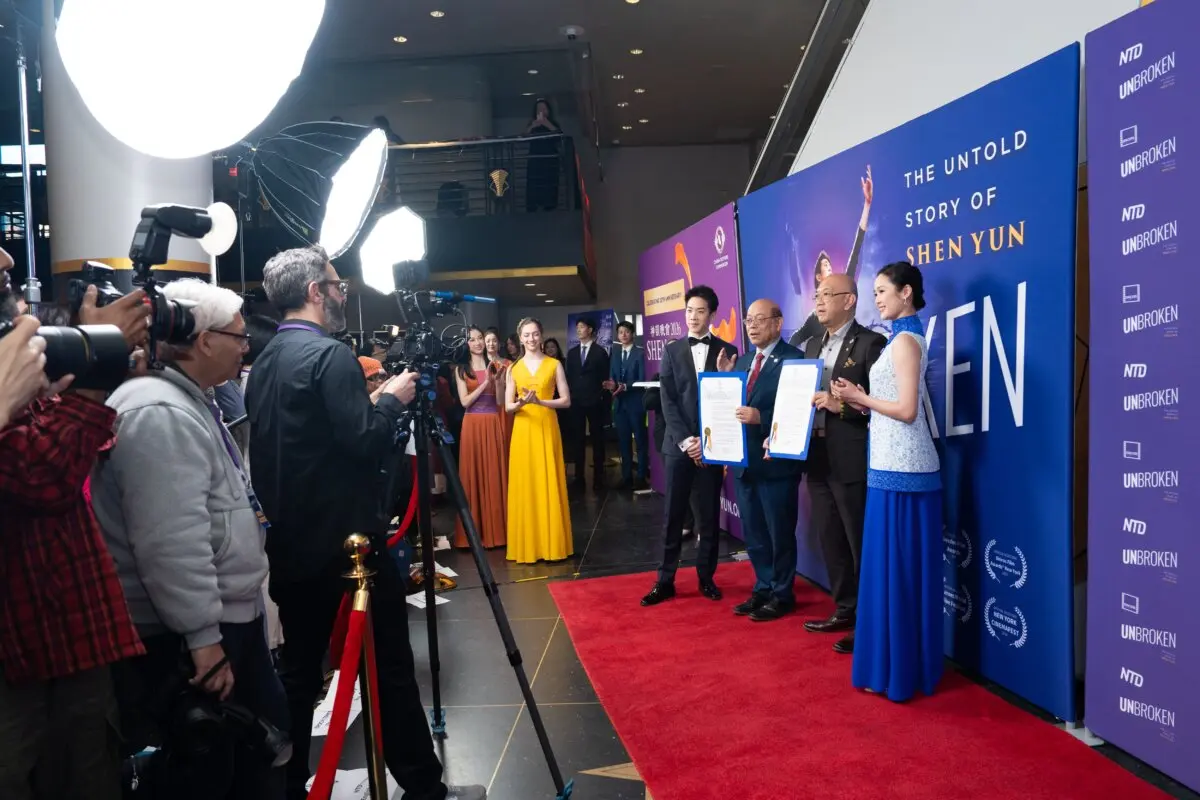 New York Councilman Phil Wong (2nd L) and constituent services liaison Bernard Chow (2nd R) present a proclamation for Shen Yun Performing Arts alongside Shen Yun principal dancers Piotr Huang (L) and Angelia Wang (R) at the worldwide premiere of "Unbroken: The Untold Story of Shen Yun" at AMC Theater at Lincoln Square in New York City on March 24, 2026. (Samira Bouaou/The Epoch Times)