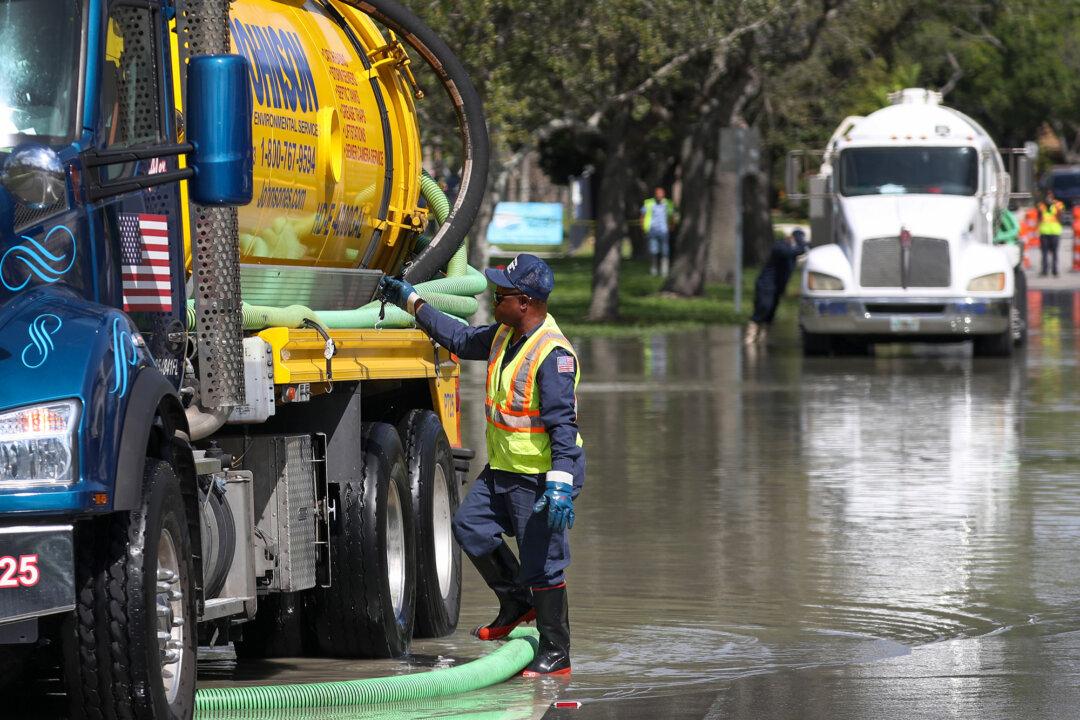 A worker uses a vacuum truck to remove sewer water after a sewer main break in Fort Lauderdale, Fla., on Feb. 24, 2020. Much of the nation’s aging wastewater infrastructure is nearing the end of its lifespan, with thousands of spills each year exposing millions to contamination risks. (Joe Raedle/Getty Images)