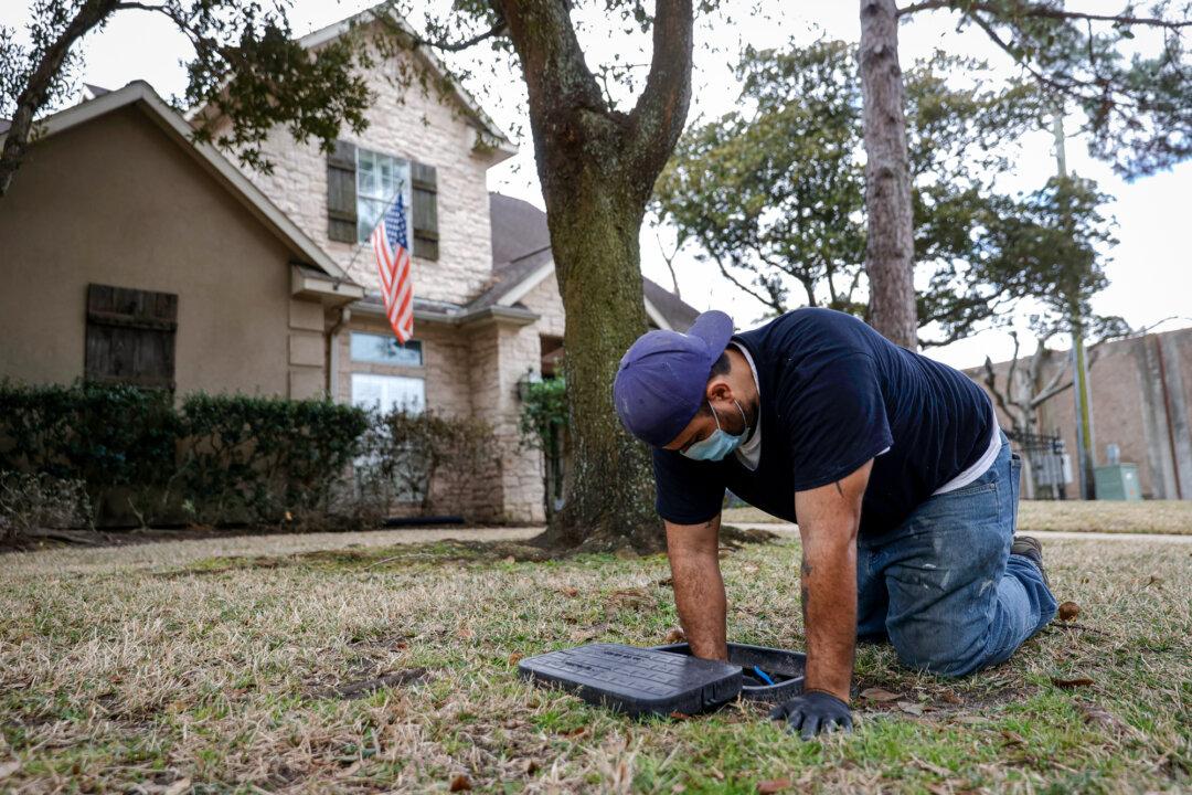 A plumber turns the water back on after repairing a burst pipe in a home in Houston on Feb. 21, 2021. Bland Warren said that as weather patterns shift, wastewater systems and storage infrastructure are often required to manage more variable conditions. (Justin Sullivan/Getty Images)