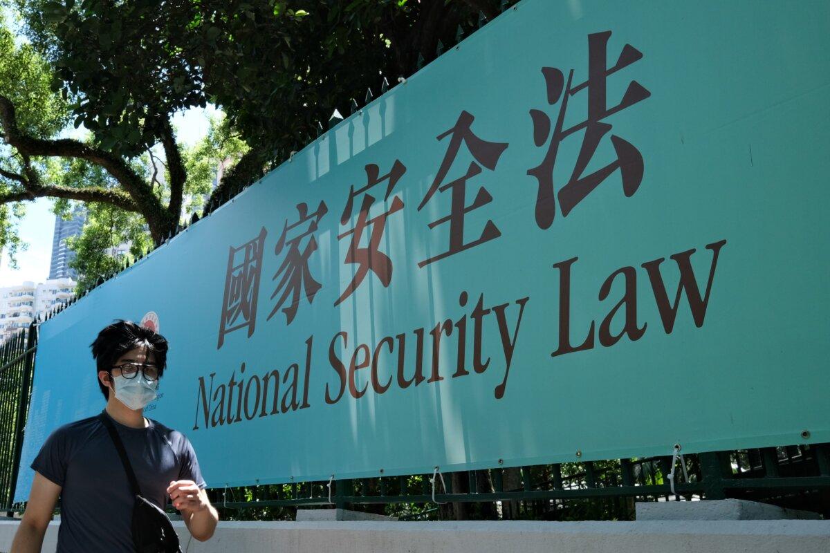 A man walks past a government public notice banner for the National Security Law in Hong Kong on July 15, 2020. (Anthony Wallace / AFP via Getty Images)