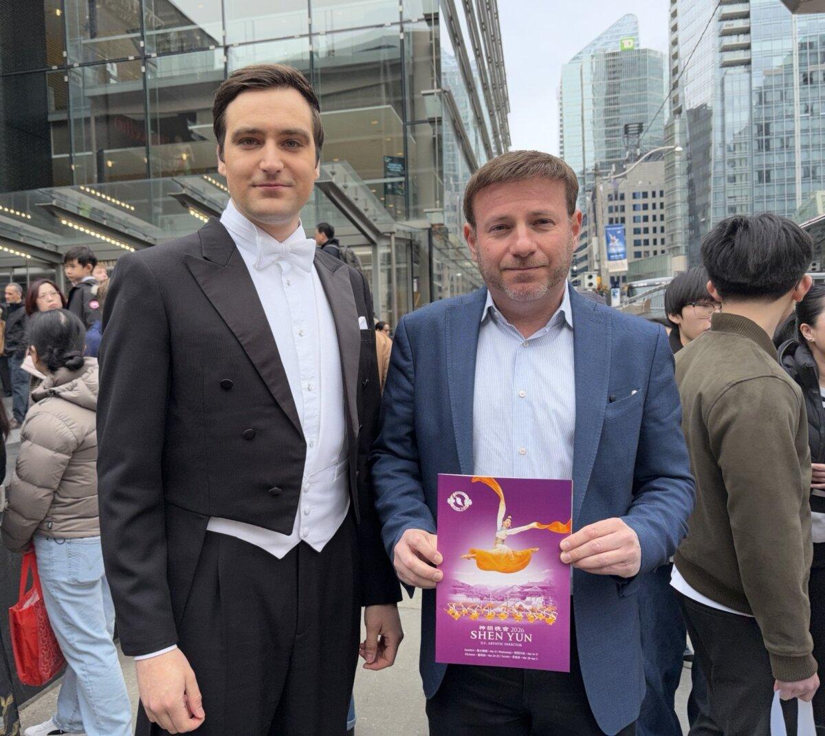 Conservative MP Roman Baber holds a Shen Yun program book while standing by one of the show's hosts outside the Four Seasons Centre for the Performing Arts in Toronto on March 29, 2026. (The Epoch Times)