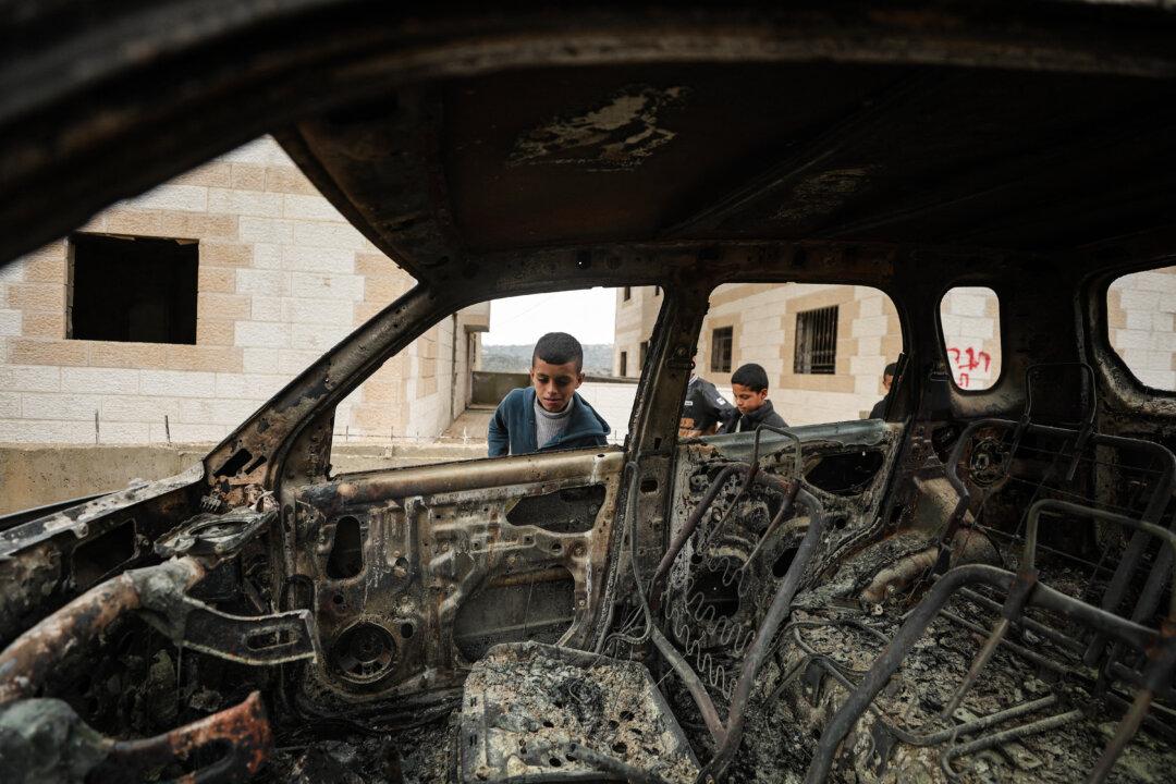 Residents inspect damage to burned vehicles after Israelis conducted a raid in the Rahve area near Beit Fajjar, in northern Hebron in the West Bank on March 30, 2026. (Mosab Shawer / Middle East Images / AFP via Getty Images)