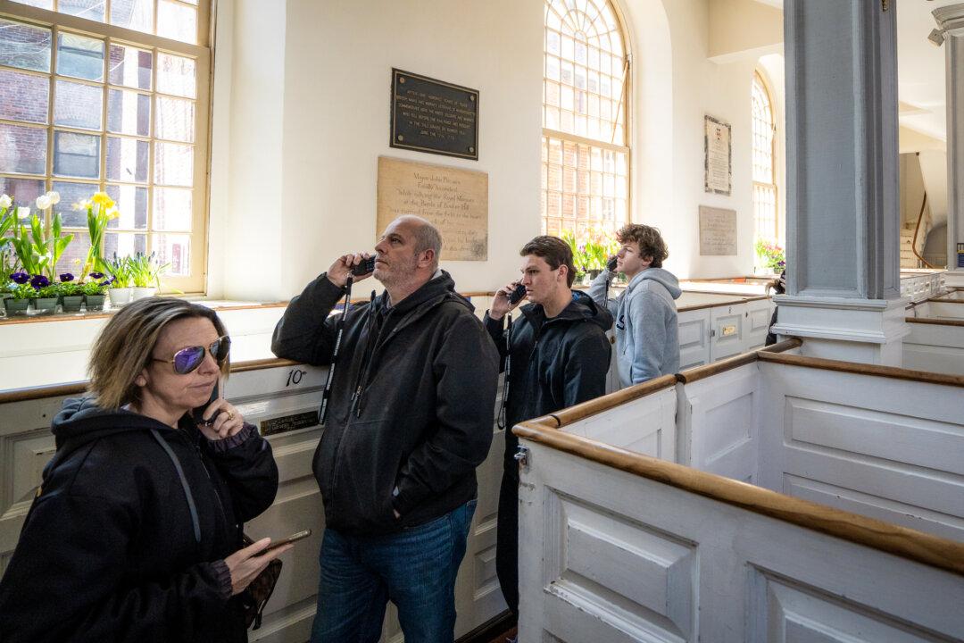 Visitors listen to handheld audio devices for self-guided tours, at Old North Church in Boston on April 8, 2026. (Samira Bouaou/The Epoch Times)