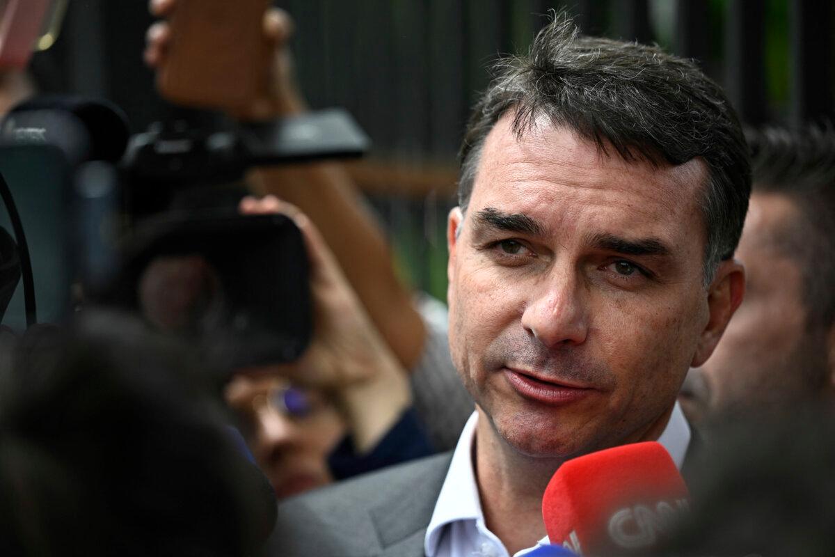 Sen. Flavio Bolsonaro, son of former Brazilian President Jair Bolsonaro, speaks with journalists after leaving the Federal Police headquarters where his father is being held in Brasilia on Dec. 9, 2025. (Ton Molina/AFP via Getty Images)