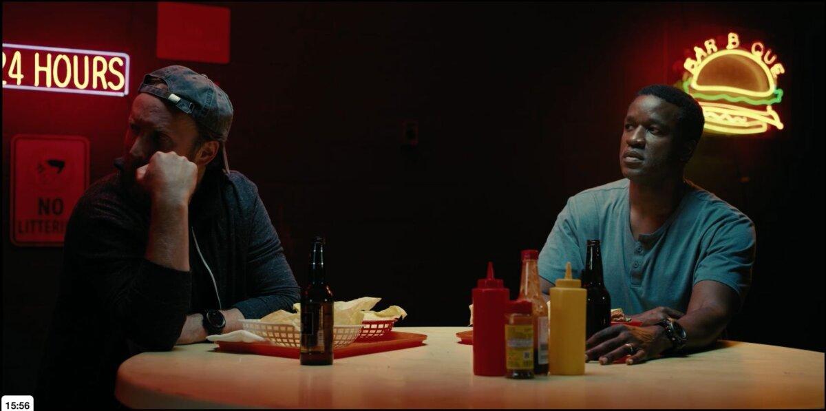 Alexander Slinger (Joshua Close, L) and Auggie (Gilbert Owuor) in a burger joint, in "American Solitaire." (Executive Productions)