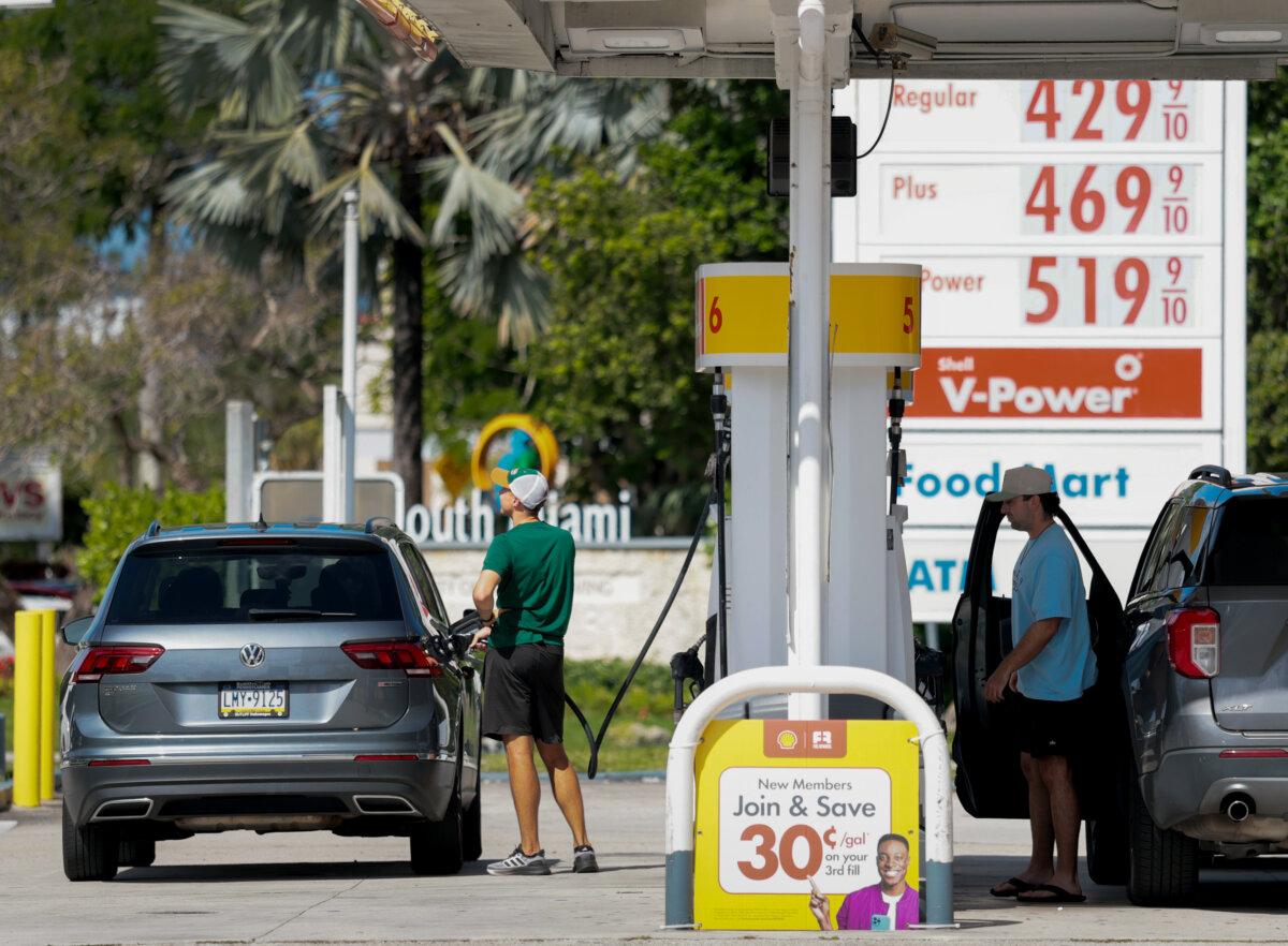 Gasoline prices are displayed on a sign as customers fill their vehicles at a gas station in Miami on April 13, 2026. (Joe Raedle/Getty Images)