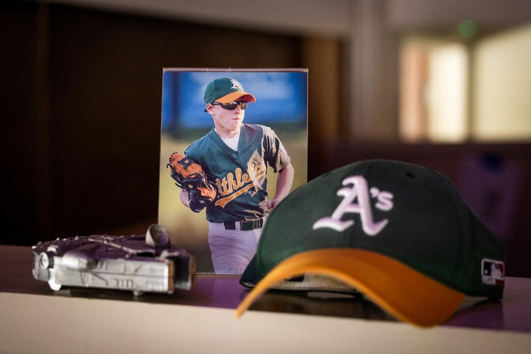 (Left) Judy Rogg holds one of the baseballs used and written on by her deceased son Erik in Los Angeles on April 15, 2026. (Right) A photo of Erik Robinson sits next to items he owned in Los Angeles on April 15, 2026. (John Fredricks/The Epoch Times)