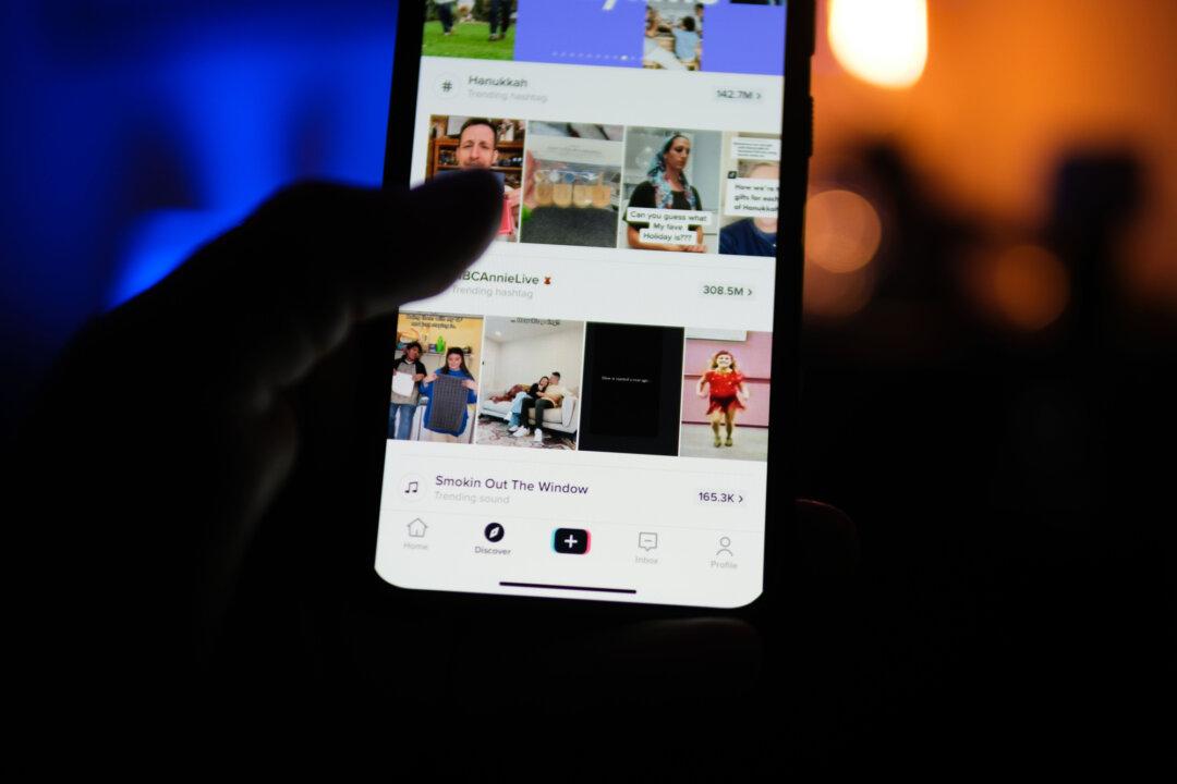 A man holds a phone displaying the TikTok app in this file photo. Around 63 percent of U.S. teens use TikTok, according to the Pew Research Center. (Oleksii Pydsosonnii/The Epoch Times)