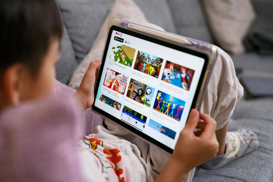 A young boy looks at his iPad screen with the YouTube Kids app open in Sydney on Dec. 7, 2025. (George Chan/Getty Images)