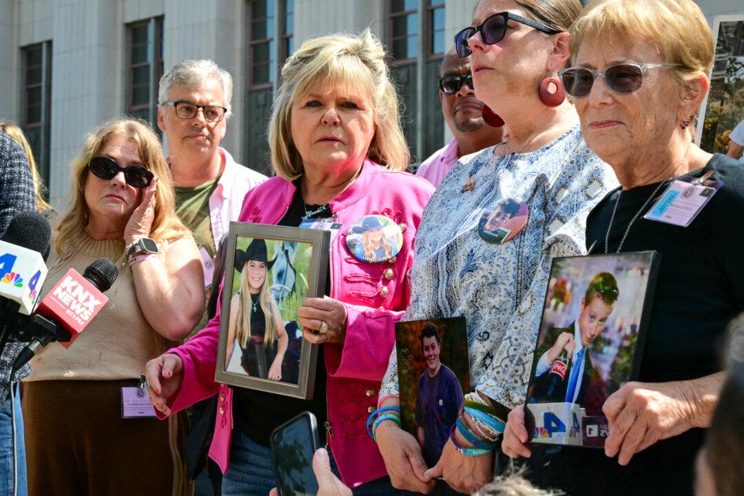 Relatives of victims stand outside the Los Angeles Superior Court holding portraits of their loved ones in Los Angeles on March 25, 2026. While Section 230 of the Communications Decency Act has historically provided a bulletproof legal shield for social media platforms, recent decisions are chipping away at it. (Frederic J. Brown/AFP via Getty Images)