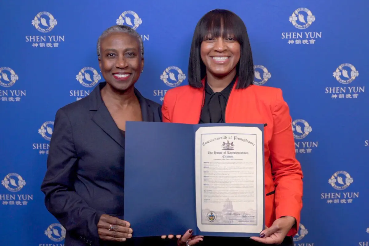 District Office Director Brenda Mills (R) presents a Citation to Shen Yun Performing Arts on behalf of Rep. Regina Young at the Miller Theater on April 18, 2026. (NTD)