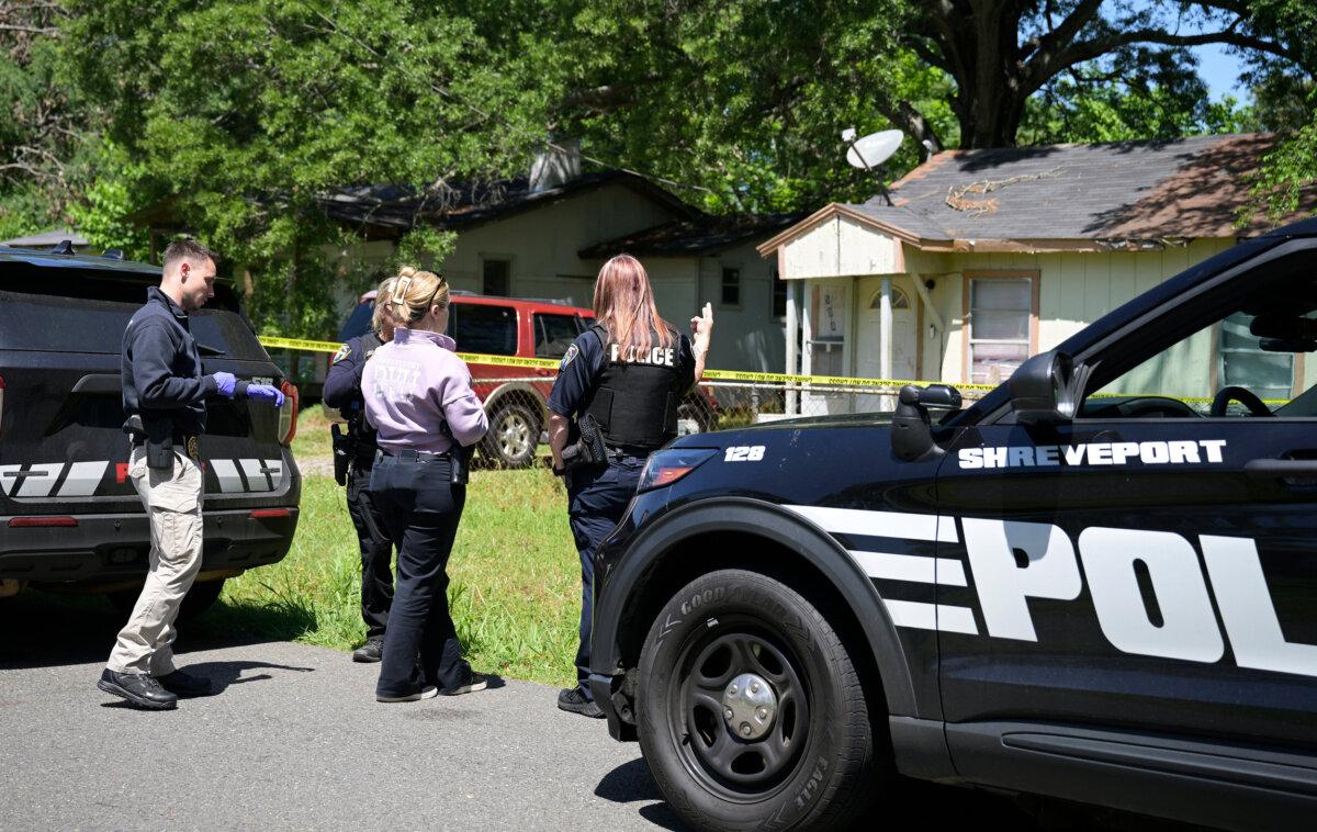 Police gather in front of a house on Harrison Street near Bernstein Avenue, in Shreveport, La., as they investigate a shooting, on April 19, 2026. (Jill Pickett/The Times-Picayune/The New Orleans Advocate via AP)