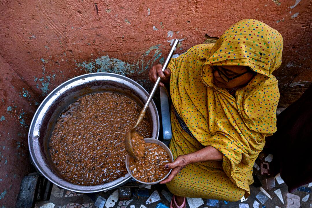 A Sudanese woman prepares a free meal canister at the home of the founder of the "Community Kitchen" initiative in Omdurman on April 21, 2026. The top United Nations official in Sudan told AFP on April 16, 2026, that the country, facing the world's largest humanitarian crisis, has been "abandoned" as the war between the army and the paramilitary Rapid Support Forces (RSF) enters its fourth year. (Photo by Khaled DESOUKI / AFP via Getty Images)