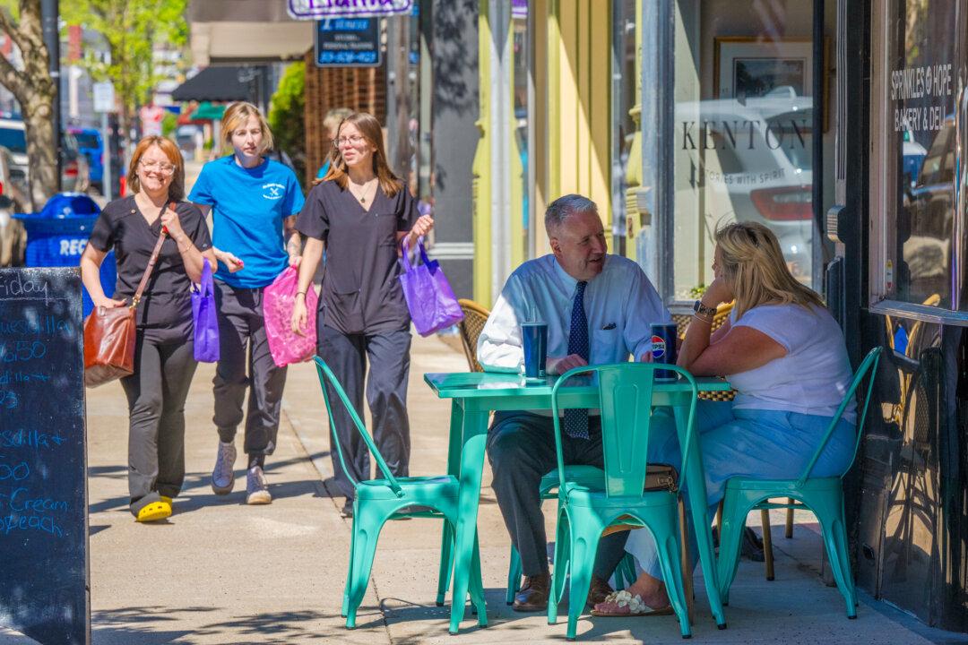 Pedestrians and diners walk along West Second Street in Maysville, Ky., on April 10, 2026. Mason County farmers and residents who are against the data center project are anxious about what will happen to the water, air, and quality of life if the facility is built. (Glenn Hartong for The Epoch Times)