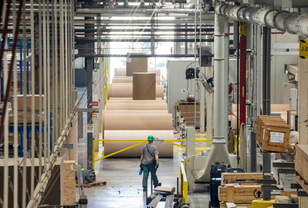 Rolls of paper are prepared for the manufacturing of cardboard box packaging at Cascades in Drummondville, Que., on Friday, March 27, 2026. (The Canadian Press/Christinne Muschi)