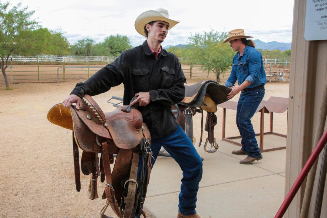 Arizona Cowboy College attendees Alec (Left) from Florida and Carmine (Right) from Prescott, Ariz., get a hands on view of cowboy life at the college's facility in Scottsdale, Ariz., on April 13, 2026. (Richard Moore/The Epoch Times)