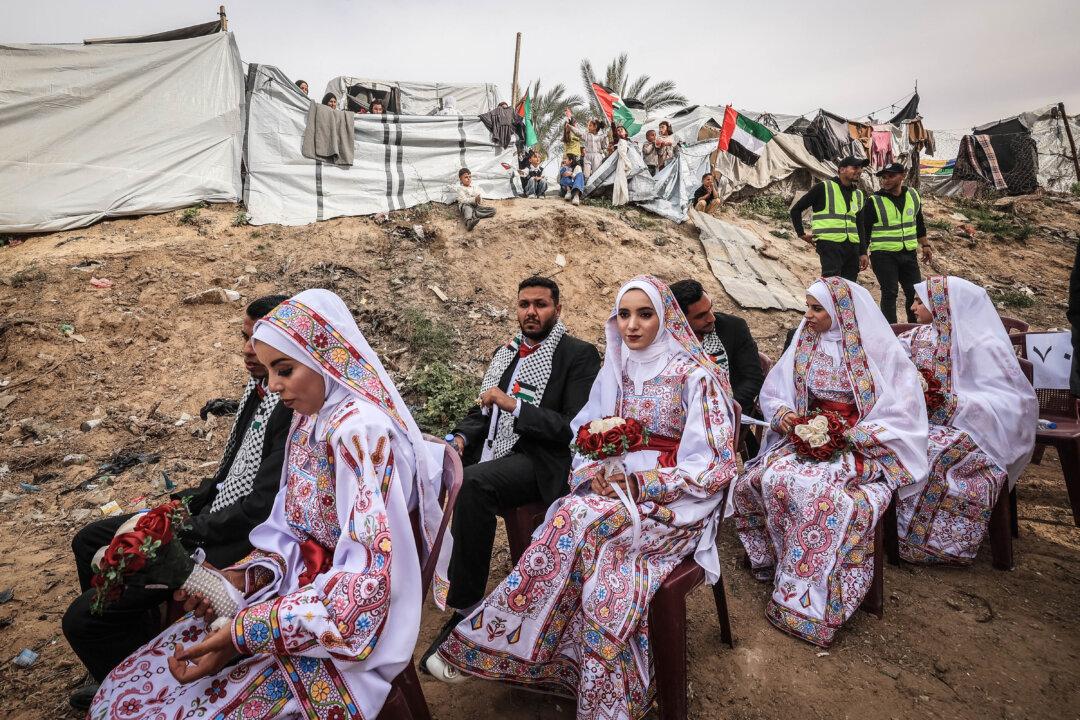 Palestinian brides and grooms wait to be wed during a mass wedding ceremony called 'The Dress of Joy 2' for around 300 couples in Deir Al-Balah, in the central Gaza Strip on April 24, 2026. (Photo by EYAD BABA / AFP via Getty Images)