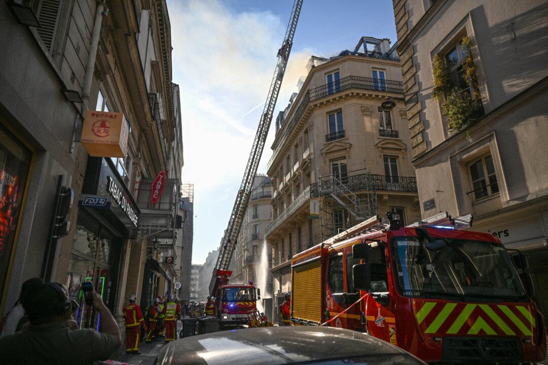 French firefighters work on the site of a fire that broke out in the roof of a building in central Paris on April 24, 2026. (Photo by Blanca CRUZ / AFP via Getty Images)