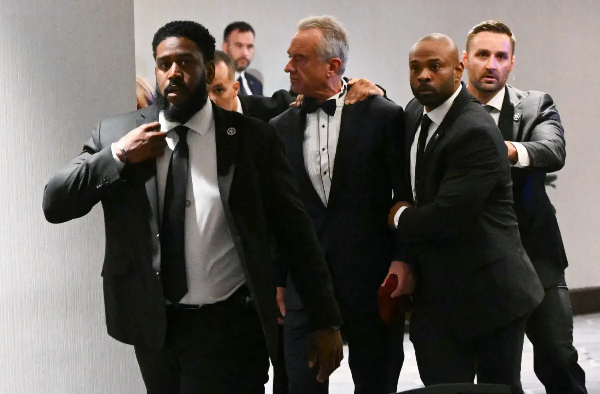 Health Secretary Robert F. Kennedy Jr. is rushed out by Secret Service agents after loud bangs were heard during the White House Correspondents' dinner at the Washington Hilton in Washington on April 25, 2026. (Mandel NGAN / AFP via Getty Images)