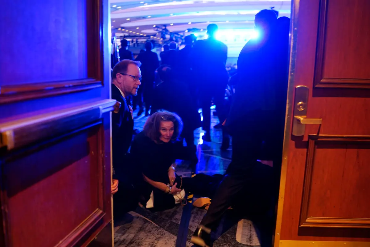Shots Fired at White House Correspondents’ Dinner, Trump Evacuated, Suspect Detained | USNN World News People take cover after an incident at the annual White House Correspondents Association Dinner in Washington on April 25, 2026. (Nathan Howard/Getty Images)