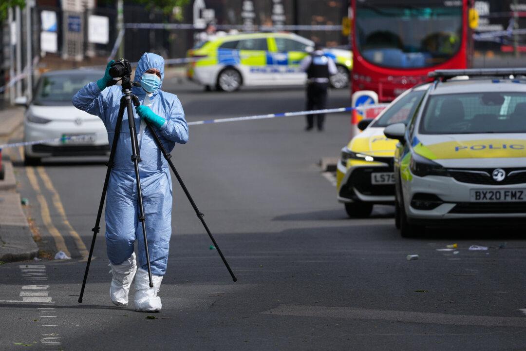 A forensic police officer photographs the scene where two people were stabbed in the Golders Green area of London, on April 29, 2026. (Carl Court/Getty Images)